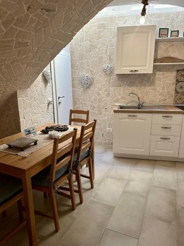 a kitchen with a table and chairs and a sink at Ercolano Civitas in Ercolano