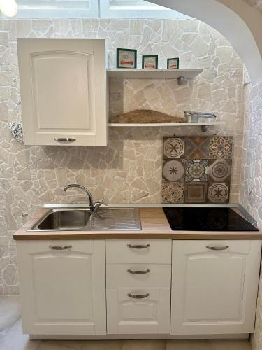 a kitchen with white cabinets and a sink at Ercolano Civitas in Ercolano