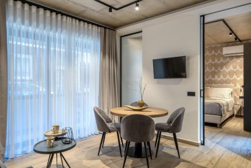 a room with a table and chairs and a bed at Amphora Nafplio- elegance Suites Apartmenthouse in Nafplio