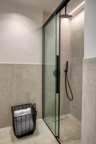 a glass shower in a bathroom with a basket at Amphora Nafplio- elegance Suites Apartmenthouse in Nafplio