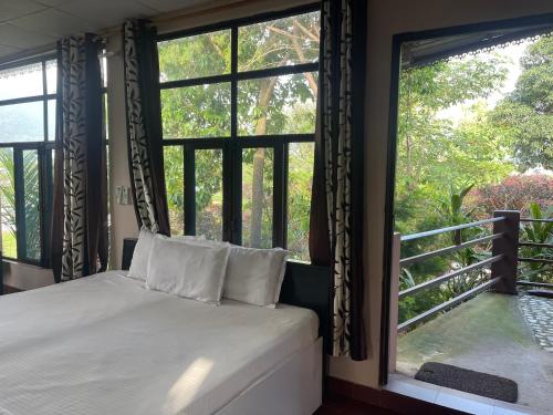a bedroom with a bed and a large window at Oxygen Homestay-A Blissful Retreat in Dehradun