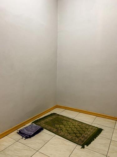 a corner of a room with a rug on the floor at Romadhoni Homestay in Magelang