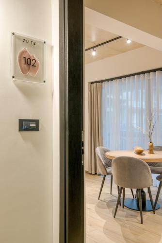 a dining room with a table and a clock on the wall at Amphora Nafplio- elegance Suites Apartmenthouse in Nafplio
