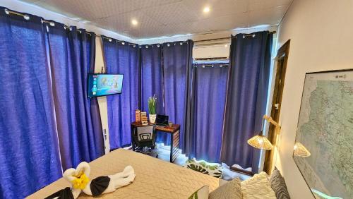 a bedroom with purple curtains and a bed with a flower on it at Casa Ejecutiva Boquete in Boquete