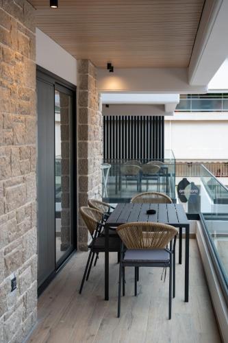 a patio with a table and chairs on a balcony at Amphora Nafplio- elegance Suites Apartmenthouse in Nafplio