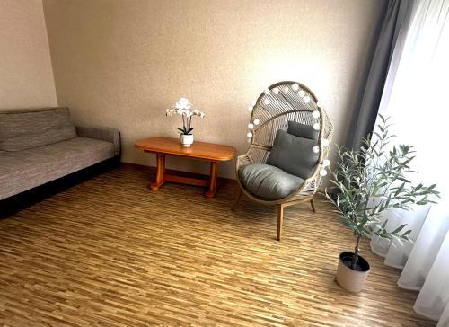 a living room with a chair and a table at Welcome Home in Ventspils
