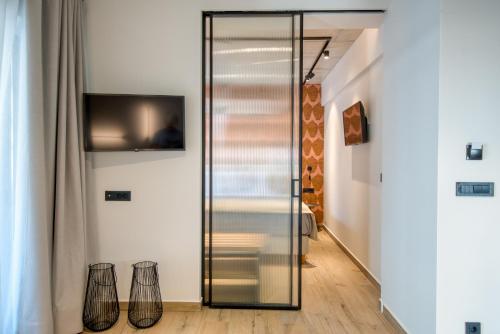 a glass door in a room with a tv at Amphora Nafplio- elegance Suites Apartmenthouse in Nafplio