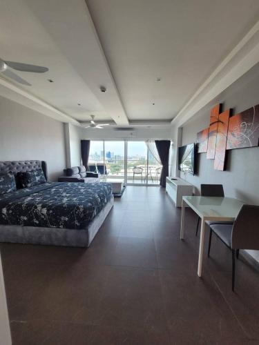 a bedroom with a bed and a desk and a table at View Talay6 by Blue Ocean Suite in Pattaya Central