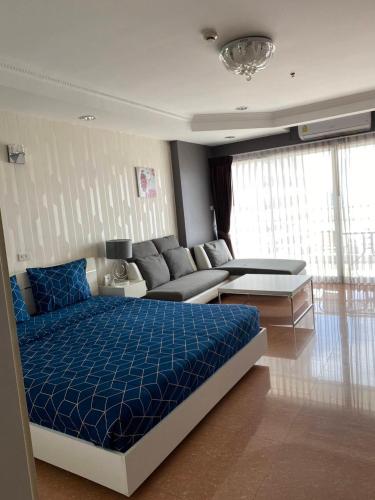 a bedroom with a blue bed and a couch at View Talay6 by Blue Ocean Suite in Pattaya Central