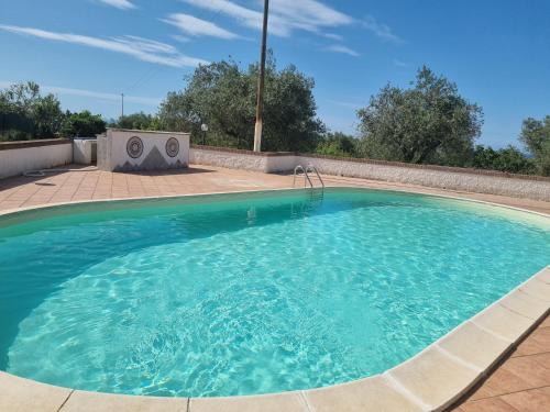 a large swimming pool with blue water at Villa Maddalena guest house in Sorso