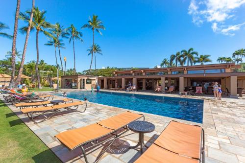 a swimming pool with chairs and a resort at Wailea Elua 702 - Ocean Views, Central AC, Wi-Fi in Wailea