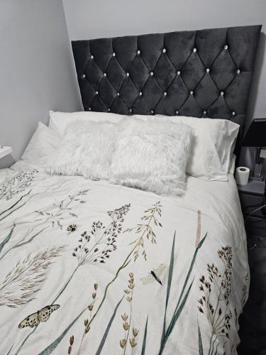 a bed with a black headboard and a white blanket at WOREM HOUSe-2 FOR 1 in Manchester