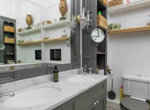 a bathroom with a sink and a clock on the wall at Breathtaking Walpole Sea Views in Margate
