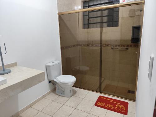 ein Badezimmer mit Toilette und Dusche in der Unterkunft Ferdin Hostel e Pousada in Joinville