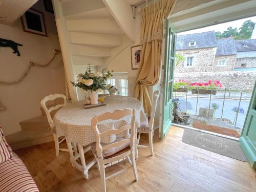 une salle à manger avec une table et des chaises et une fenêtre dans l'établissement La Petite Madeleine is a Charming 2 Bedroom Pet Friendly Gite situated on Dinan Port, à Dinan