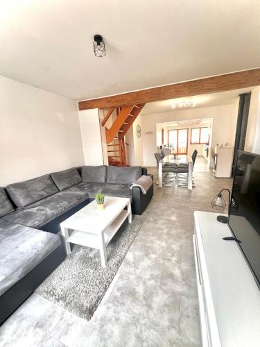 un salon avec un canapé et une table dans l'établissement La Verrière d'Opale - Maison proche plage et CNPE EDF, à Grand-Fort-Philippe