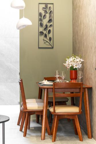 a dining room table with two chairs and a table with flowers at The Rich Villas House Pool Chalong Robinson in Ban Suan