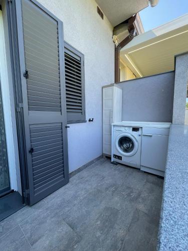 a washing machine in a laundry room with a door at Casa di Jo in Empoli