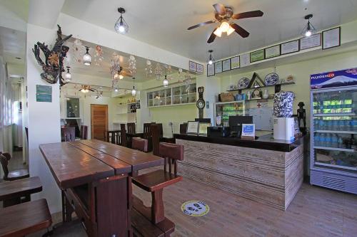 a restaurant with a counter and a table and chairs at Foxtail Siargao Island Guesthouse in General Luna