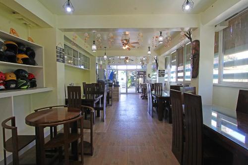 a dining room with tables and chairs in a restaurant at Foxtail Siargao Island Guesthouse in General Luna