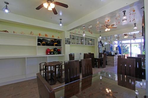 a restaurant with a dining room with tables and chairs at Foxtail Siargao Island Guesthouse in General Luna