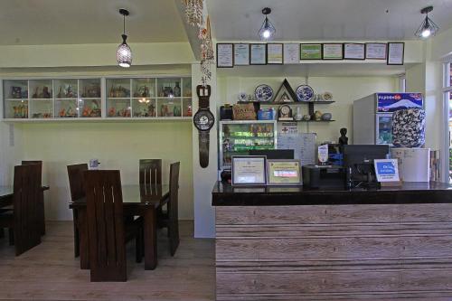 a restaurant with a counter and a table and chairs at Foxtail Siargao Island Guesthouse in General Luna