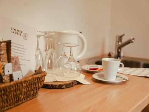 a kitchen counter with glasses and cups and a sink at Hotel Villa Freiheim in Merano
