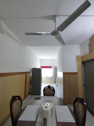 a dining room with a table and chairs and a ceiling fan at Homestay NAQ D' Kuala Kangsar in Kuala Kangsar