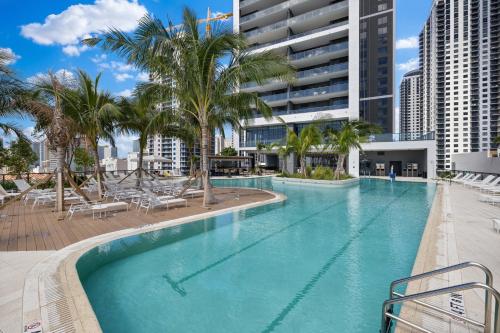 a large swimming pool with palm trees and buildings at 5108Great Penthouse, Bay view, in the heart of MIAMI in Miami