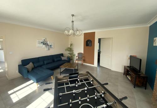 a living room with a blue couch and a table at Gite 12 personnes in Digny