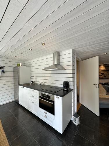 a kitchen with white cabinets and a stove at Gästhus i Kämpinge nära stranden in Höllviken