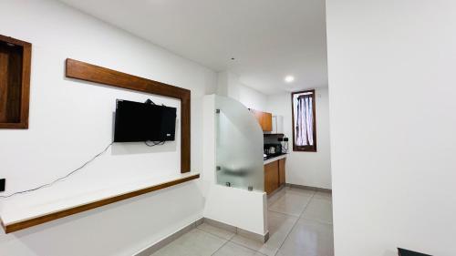 a living room with a tv on a wall at Rose Garden at Rajagiri Hospital in Ernakulam