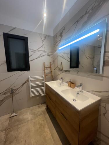 une salle de bain avec un lavabo et une télévision au mur dans l'établissement Villa Félicita 8 personnes proche plage Corse du sud, à Lecci