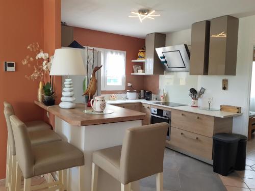 - une cuisine aux murs orange avec une table et des chaises dans l'établissement Villa Palmera - Classée 3 étoiles - Grand confort, calme, et magnifique vue dégagée, à Canet