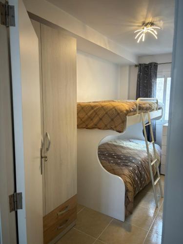 two bunk beds in a small room with a door at Apt Kandinsky Mallorca in S'Illot