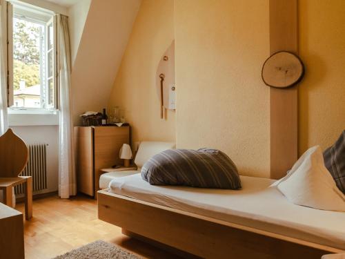 a bedroom with a bed and a clock on the wall at Hotel Villa Freiheim in Merano
