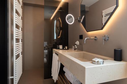 a bathroom with a large sink and a mirror at Essenza Relais Contemporaneo in Cisternino