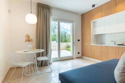 a bedroom with a bed and a table and chairs at Essenza Relais Contemporaneo in Cisternino