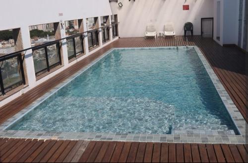 a large swimming pool in a building with chairs at Apartamento aconchegante no Centro in Campos dos Goytacazes
