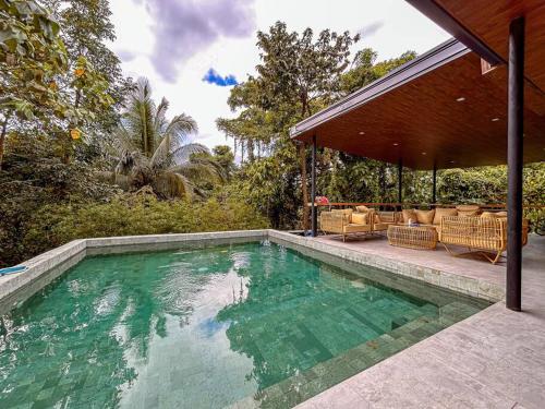 a swimming pool in front of a house at Zen Pod by Jen in Lemery