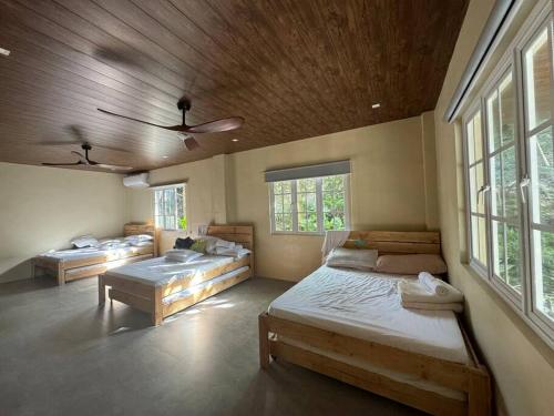 a room with three beds in it with windows at Zen Pod by Jen in Lemery