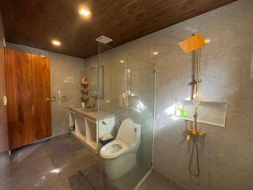 a bathroom with a toilet and a glass shower at Zen Pod by Jen in Lemery