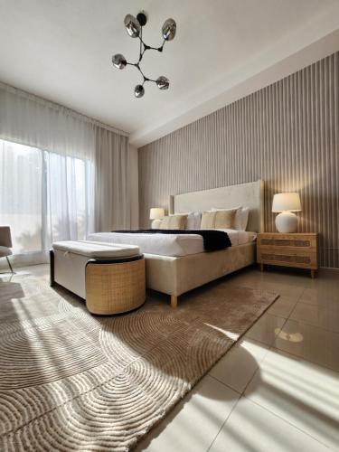 a bedroom with a large bed and a chandelier at Live and experience Al Marjan Island 1BR in Ras al Khaimah