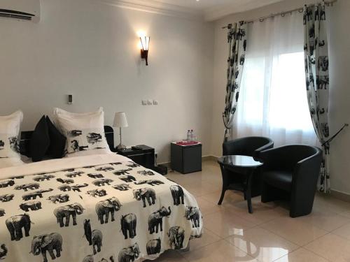 a bedroom with a bed and a table and chairs at Guest Wharf in Pointe-Noire