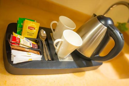a tray with a tea pot and cups on a table at Al Muhaidb Palastine - Jeddah in Jeddah