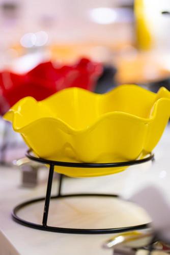a yellow plastic bowl on a stand on a table at Al Muhaidb Palastine - Jeddah in Jeddah