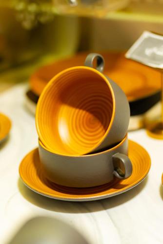 a cup on an orange plate on a table at Al Muhaidb Palastine - Jeddah in Jeddah