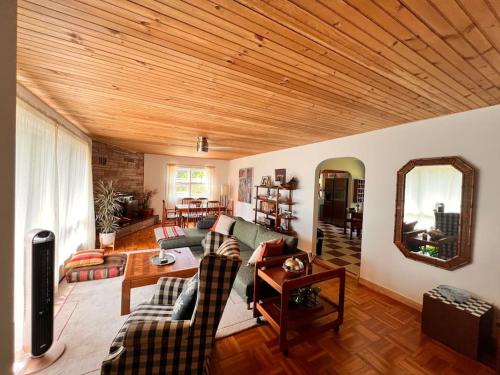a living room with couches and a wooden ceiling at The Mod Cabin in Bearsville