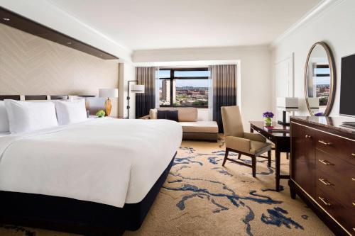 a bedroom with a large white bed and a living room at The Ritz-Carlton, Denver in Denver