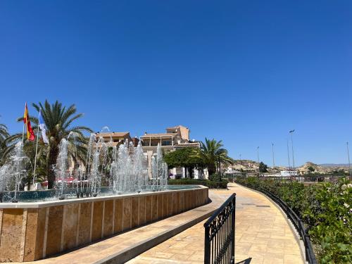 a fountain in the middle of a sidewalk with a fence at Casa Mica in Albox